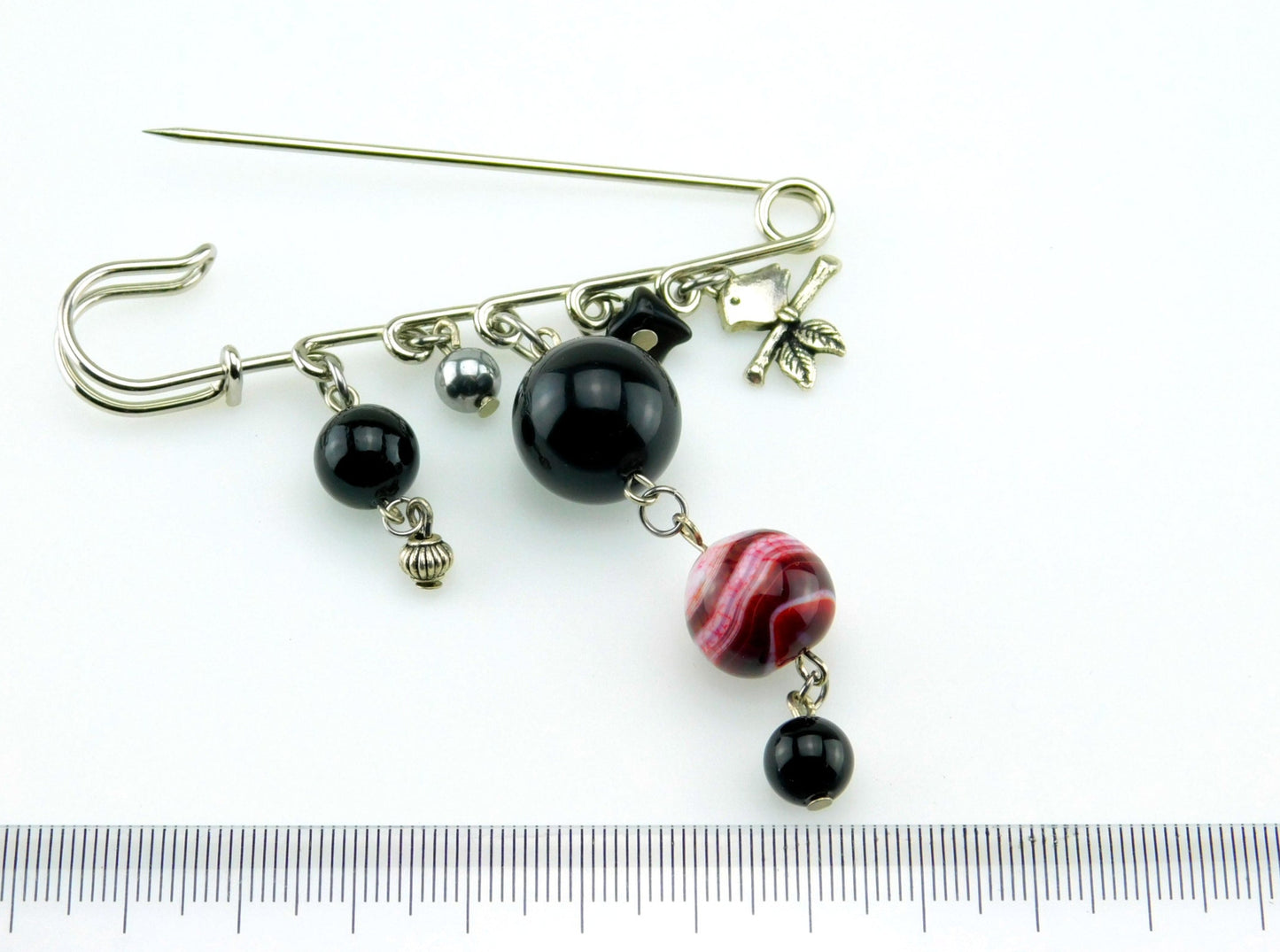 Eine Sicherheitsnadel Brosche in Silber Farbe mit Perlen und kleinen Anhängern