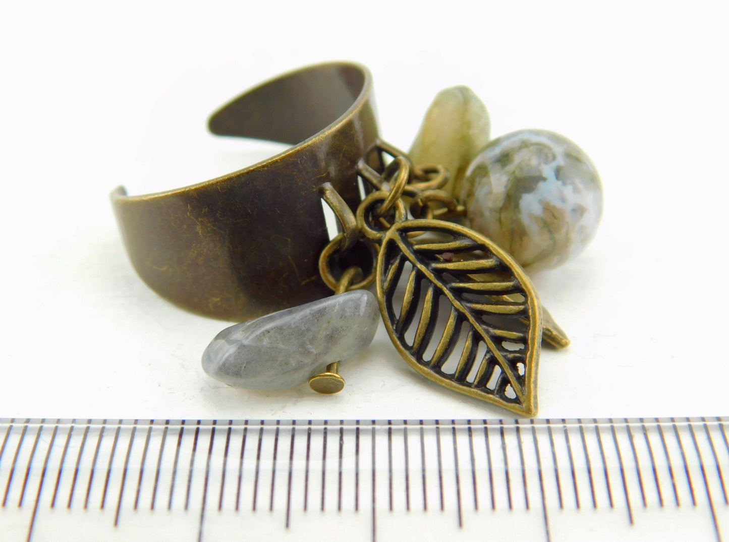 Bronzefarbener Ring mit kleinen Anhängern und Perlen