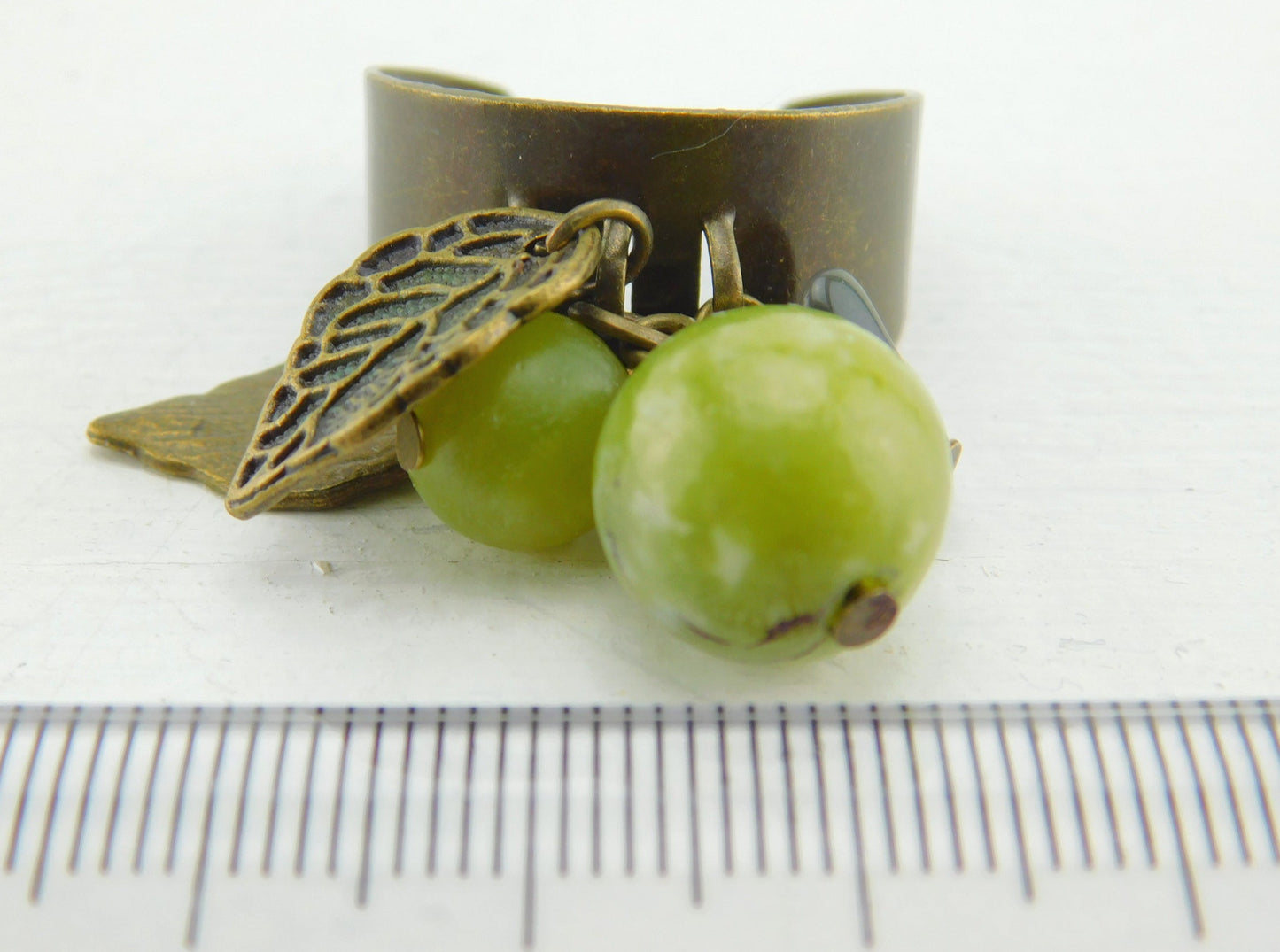 Bronzefarbener Ring mit kleinen Anhängern und Perlen