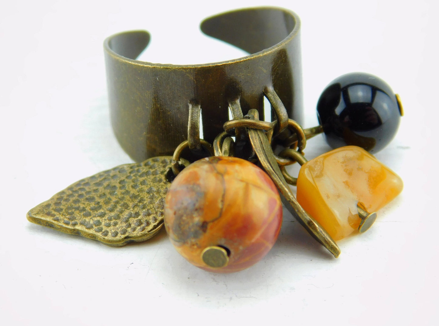 Bronzefarbener Ring mit kleinen Anhängern und Perlen