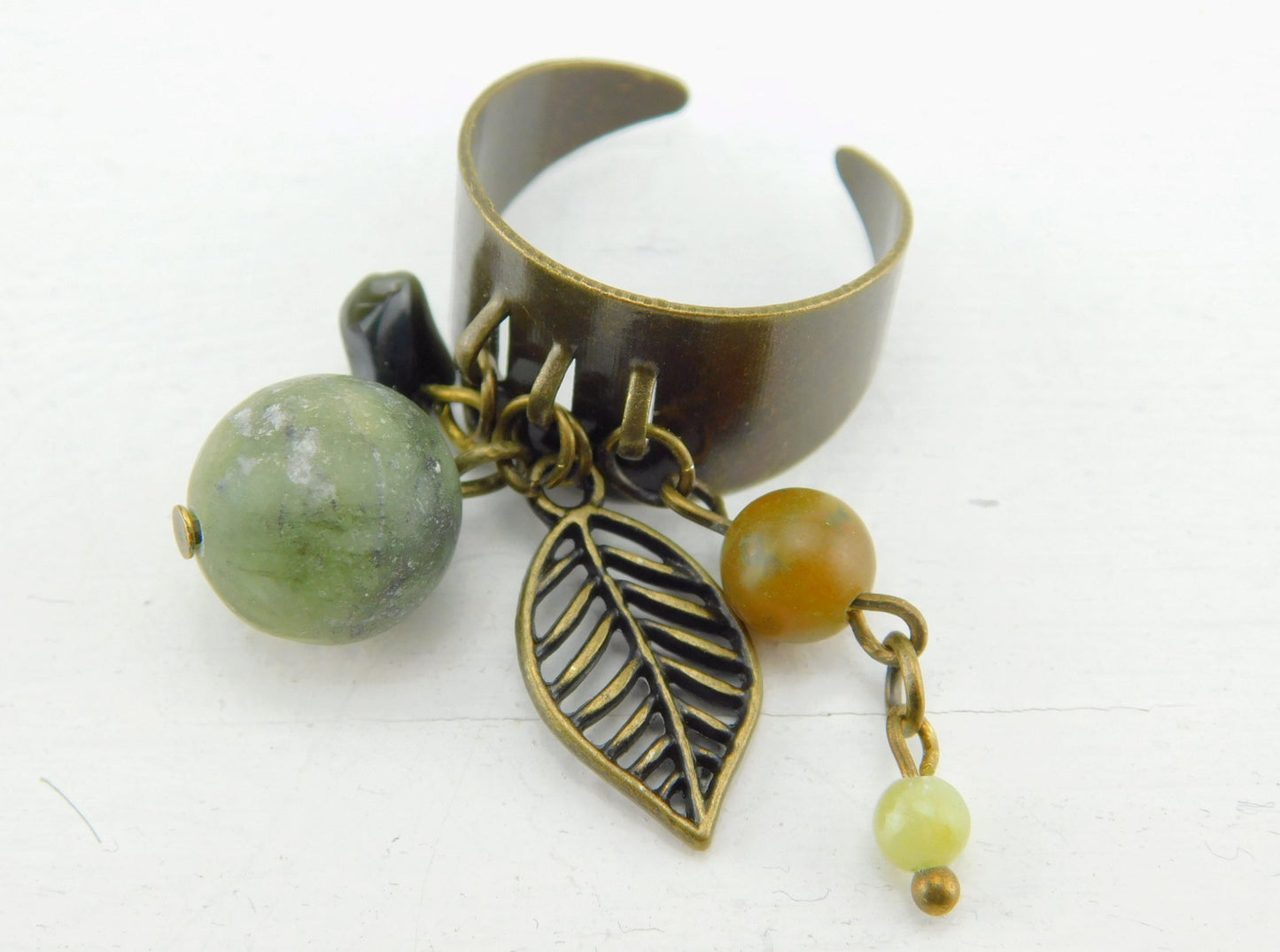 Bronzefarbener Ring mit kleinen Anhängern und Perlen