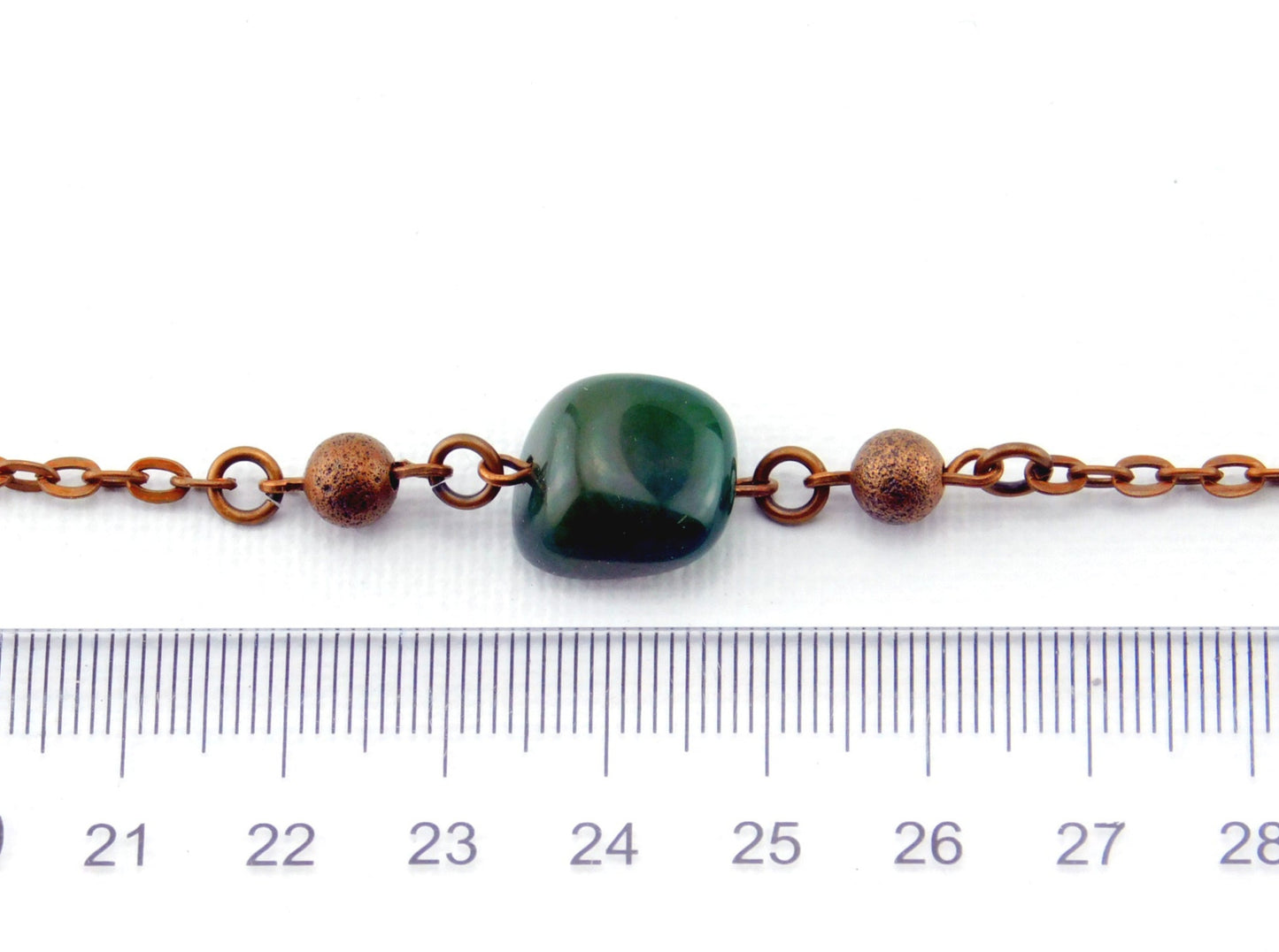 Ein kupferfarbenes Armband mit einem grünen Achatstein