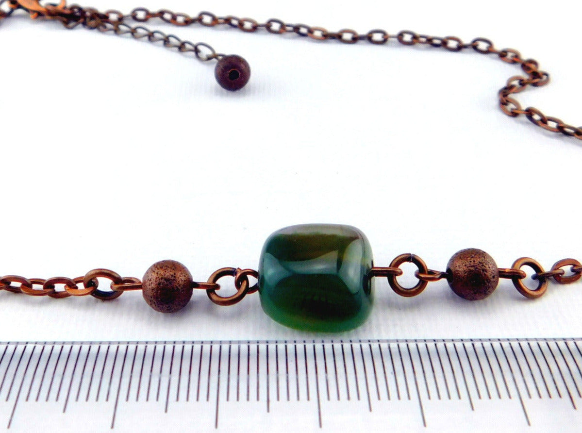 Eine kurze kupferfarbene Halskette mit einem grünen Achat