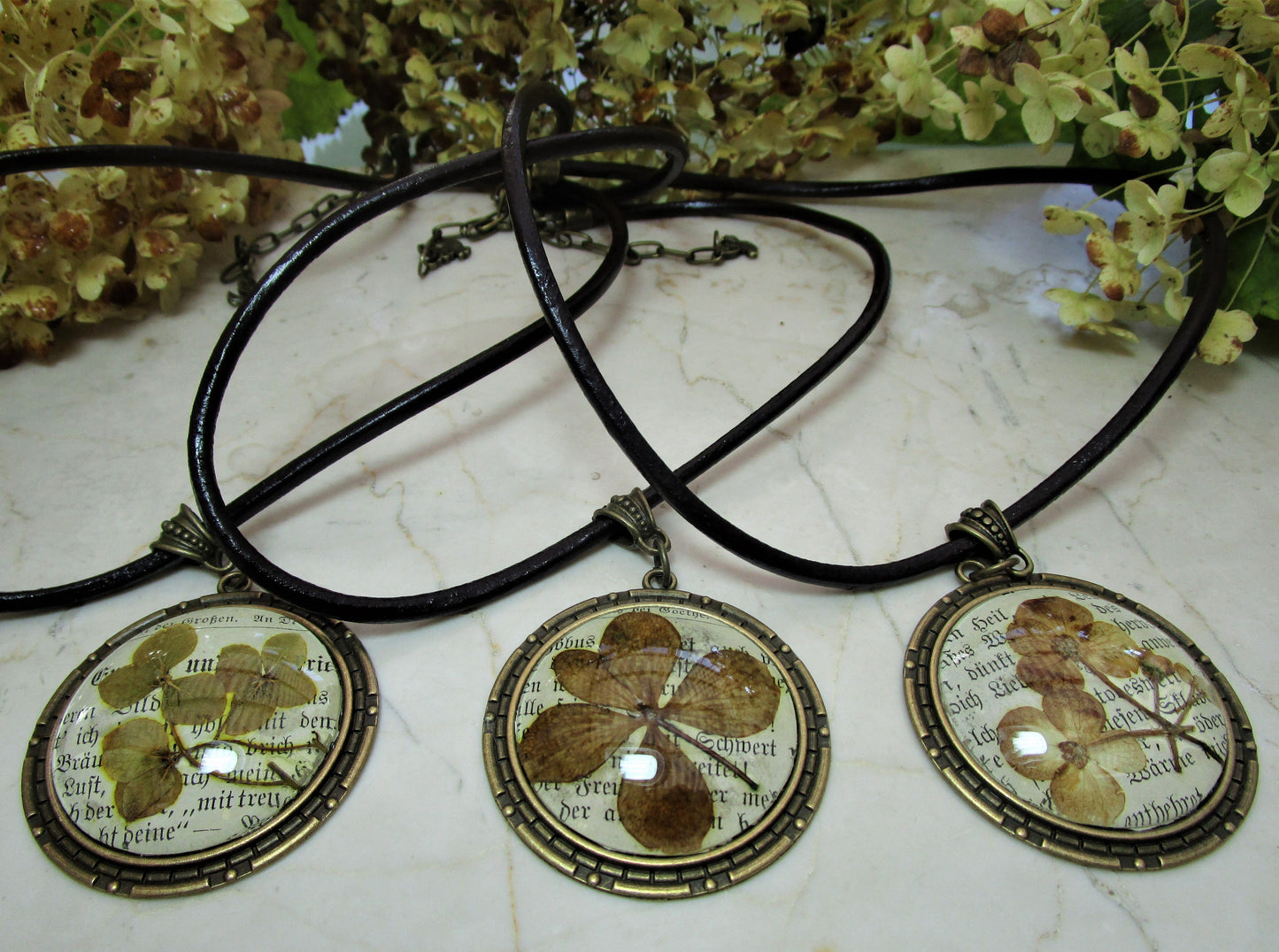 Eine Halskette "Vintage" mit echter Blüte in einem Glascaboschon mit einem Lederband in dunkelbraun - Vintage Schmuckstübchen