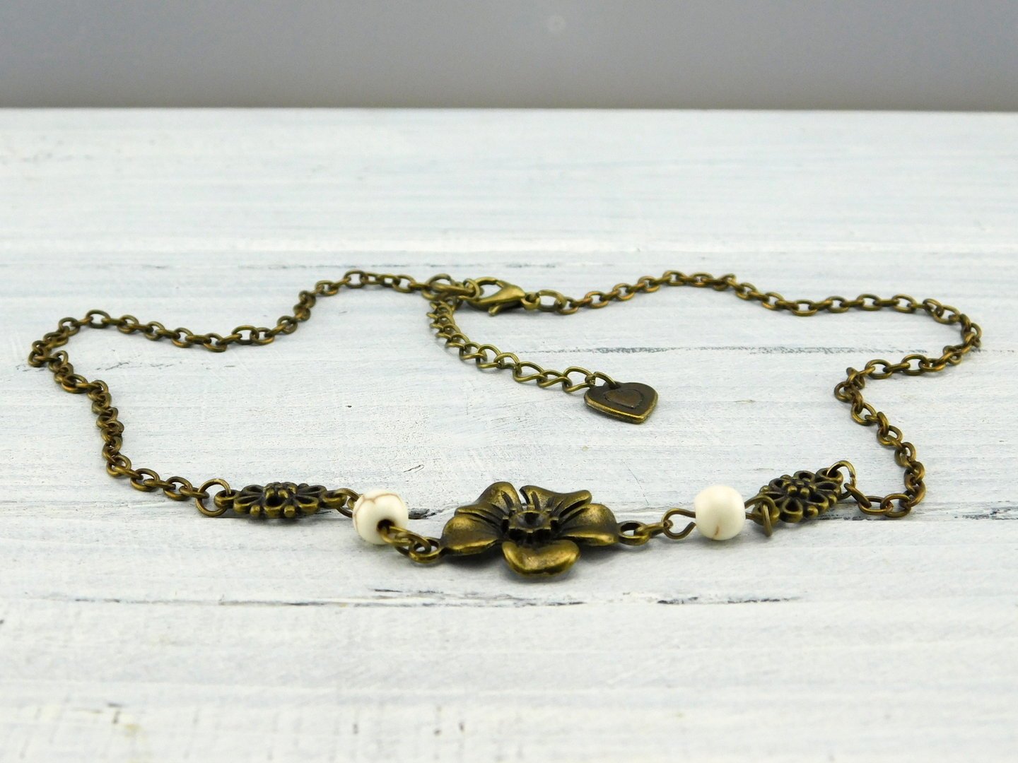 Kurze Halskette mit Blume und weißen Perlen 